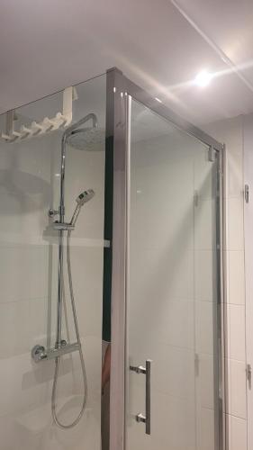 une douche avec une porte vitrée dans une salle de bain dans l'établissement La chambrée des bois, à Cadarsac