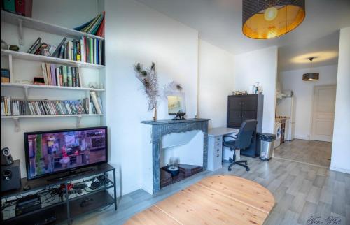 un salon avec une télévision et une cheminée dans l'établissement Le Farges-St Roch-2 chambres-LaConciergerieByNina, à Montpellier