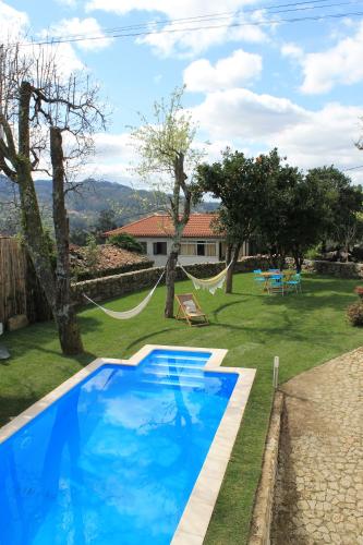 a swimming pool in the yard of a house at Casa do Couço in Sever do Vouga
