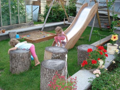 two little girls playing on a slide in a backyard at Guest House Linas in Alytus