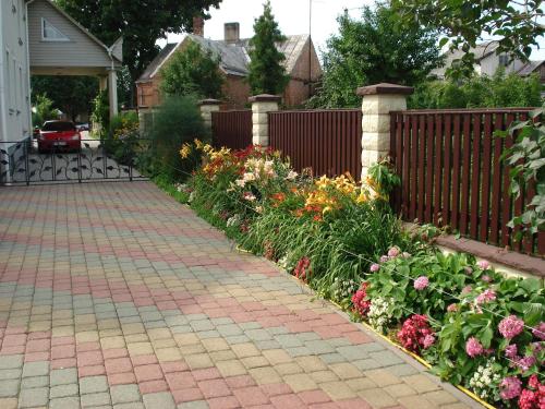 a garden of flowers in front of a fence at Guest House Linas in Alytus