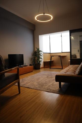 a living room with a couch and a table and a screen at Apartamento Moderno e Acolhedor I Perto do Aeroporto in Lisbon
