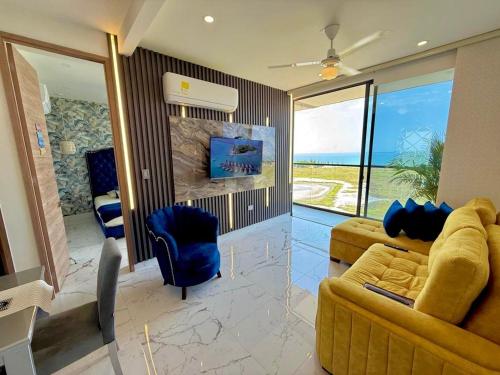 a living room with a couch and chairs and a television at Lujoso apto con vista al mar, en salinas del mar in Playa Dormida