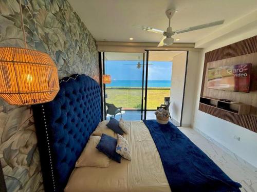 a bedroom with a blue bed with a view of the ocean at Lujoso apto con vista al mar, en salinas del mar in Playa Dormida