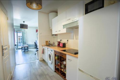 une cuisine avec des armoires blanches et une laveuse et une sécheuse dans l'établissement Le Farges-St Roch-2 chambres-LaConciergerieByNina, à Montpellier
