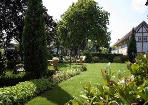 a garden with chairs and trees and a building at Landhotel Alberts in Heijenrath