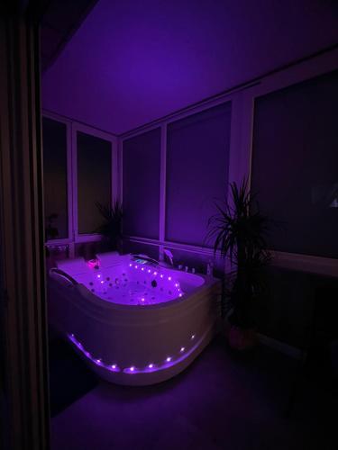 a purple room with a tub with lights in it at LuxRooms - rooms with private jacuzzi in Bjelovar
