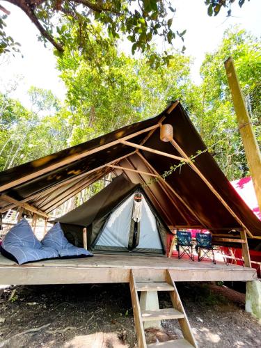 a tent with a wooden floor and a ladder at Lainkalogos Glamping in Rabia