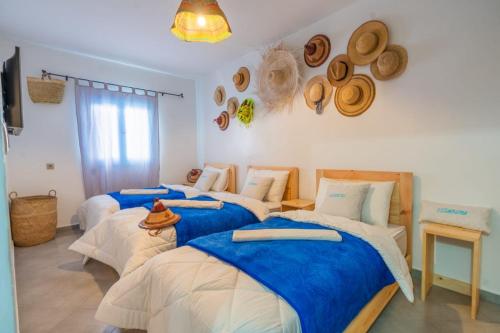 three beds in a room with hats on the wall at Moga passage bleu 2 in Essaouira
