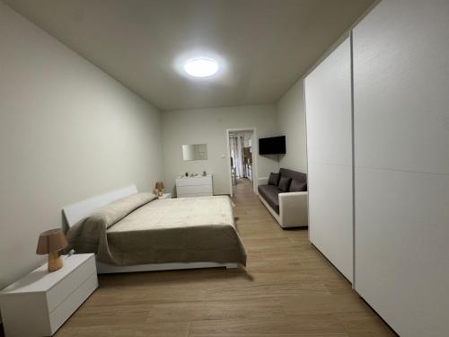 una camera da letto bianca con un letto e un divano di B&B Sofia Home a Catania