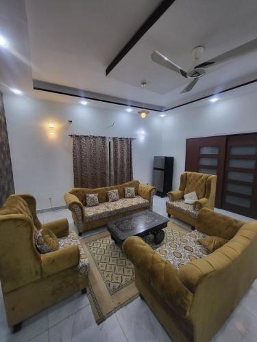 ein Wohnzimmer mit Sofas und einem Tisch in der Unterkunft Paradise in Karatschi