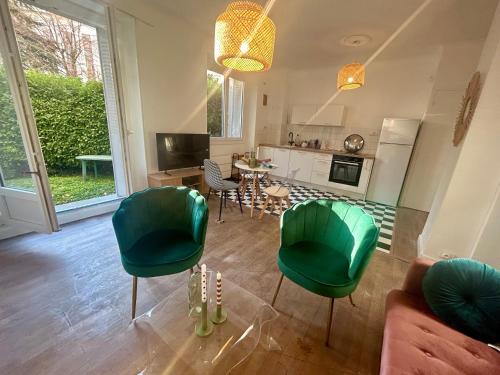 a living room with green chairs and a table at Charmant rez-de-jardin lumineux en plein centre ville de Grenoble in Grenoble