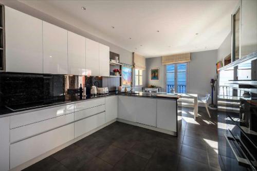 une grande cuisine avec des placards blancs et un grand sol dans l'établissement Villa located in a luxurious area, à Villefranche-sur-Mer