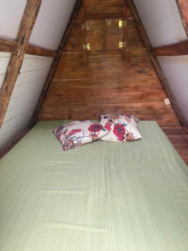 a bed with two pillows on it in a attic at La Casinha da Sorte in Sana