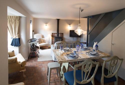 a living room with a table with chairs and a couch at No33 HILLVIEW LODGE BOUTIQUE COTTAGE in Brancaster