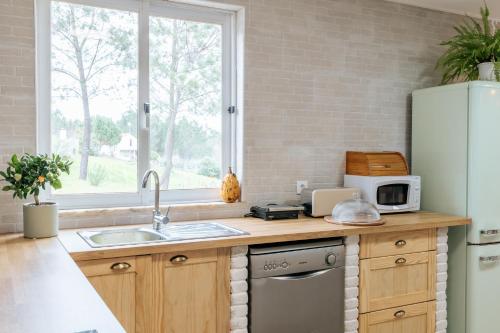 a kitchen with a sink and a refrigerator at Alma-Rio Room 3 by Mycelia in Tomar