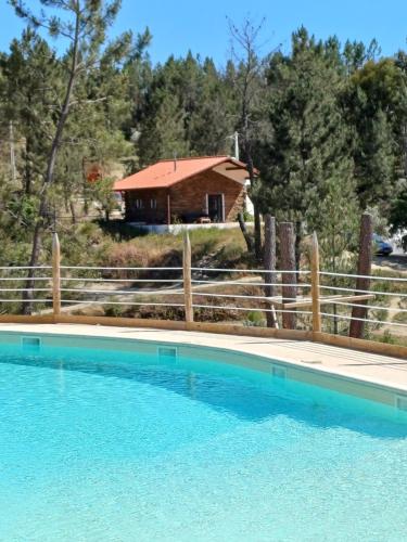 a house with a pool in front of a fence at Freedom Ville Eco Resort Portugal in Vale da Certa