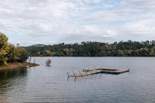 a boat sitting on a lake with a dock at Alma-Rio Room 3 by Mycelia in Tomar
