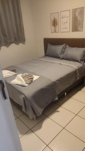 a bed sitting on a tiled floor in a bedroom at Harmonioso Ap Sete lagoas in Sete Lagoas