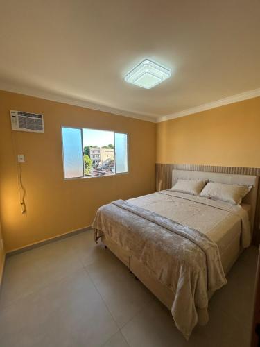 a bedroom with a bed and a window at Aconchego e paz no Centro de Vila Velha in Vila Velha
