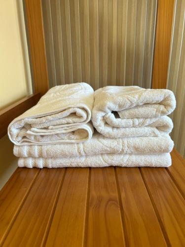 a pile of towels sitting on top of a wooden floor at Aconchego e paz no Centro de Vila Velha in Vila Velha