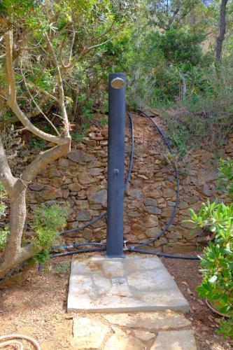 a black pole in front of a stone wall at Casa Elisio OG Innamorata, Elba in Palazzo