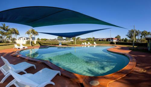 a swimming pool with two chairs and an umbrella at BIG4 Casino Holiday Park in Casino
