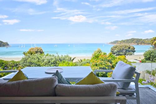 a patio with a table and chairs and the beach at Oneroa Bay - Be My Guest Waiheke in Blackpool