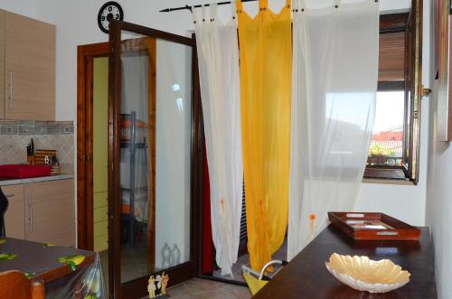 マリーナ・ディ・ピスティッチにあるBorgo Aranci Casa Vacanzeのキッチン(テーブル付)、窓(カーテン付)