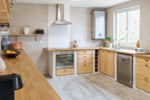 a kitchen with wooden cabinets and stainless steel appliances at Alma-Rio Dome by Mycelia in Tomar