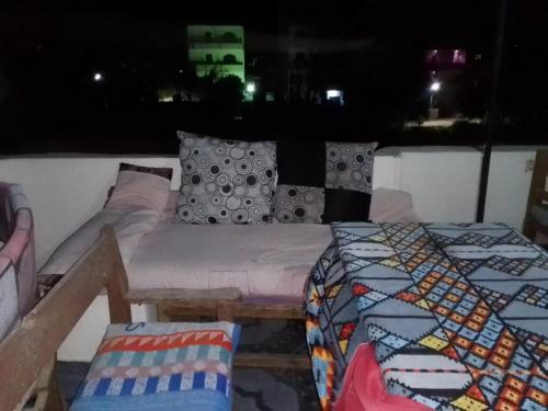 a bed and a couch in a room at night at One Love Guesthouse & Restaurant in Luxor