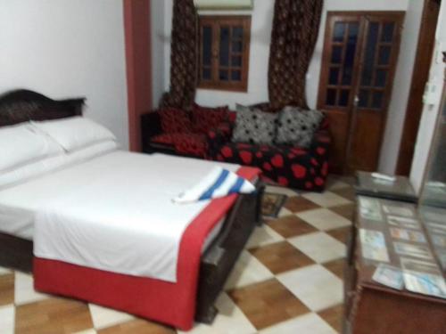 a bedroom with a bed and a couch and a table at One Love Guesthouse & Restaurant in Luxor