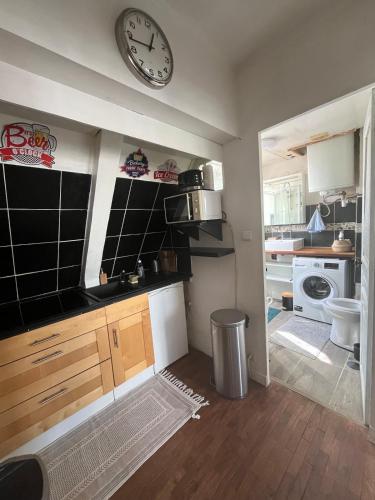 une cuisine avec une grande horloge murale dans l'établissement Cozy 2-Room Flat at Boucicaut, à Paris