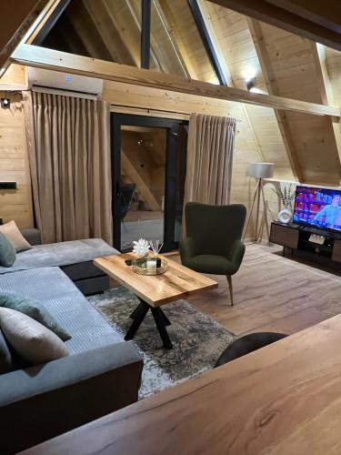 a living room with a couch and a table and a tv at Vila Jezero-Jajce in Jezero
