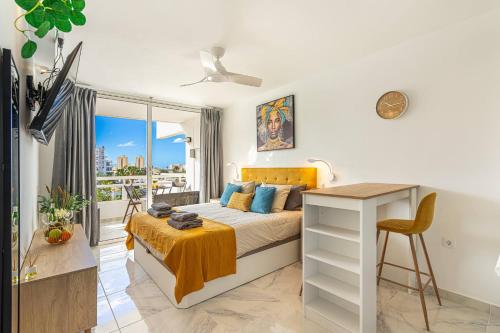 a bedroom with a bed with a desk and a window at GOLDEN VIEW Ponderosa in Costa de Adeje
