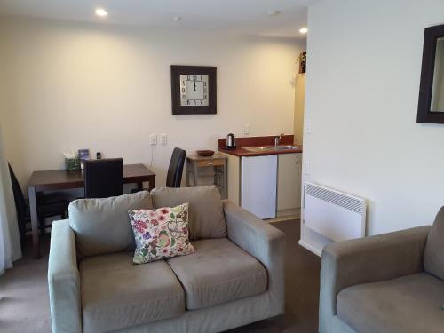 a living room with a couch and a kitchen at Tuscana Motor Lodge in Christchurch
