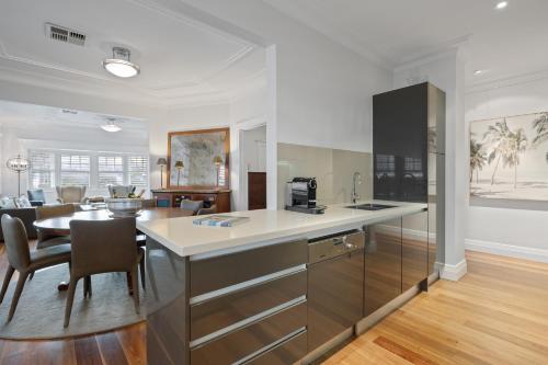 a kitchen and dining room with a counter and a table at The Bay Retreat - Neutral Bay in Sydney