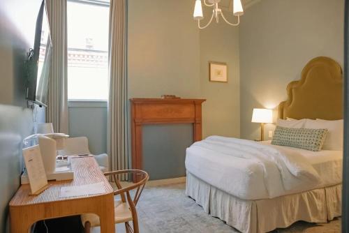 a bedroom with a bed and a table and a desk at The Woodward Hotel in Macon