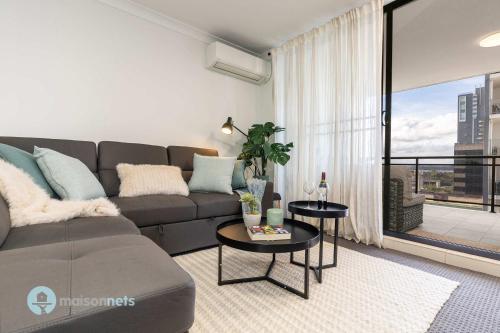 a living room with a couch and a table at 2 Bedroom 2 Bathroom Apt with Balcony and Parking in Sydney
