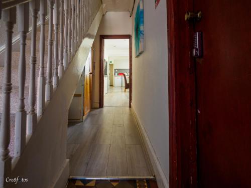 a hallway with stairs and a red door at WoodHus Lodge Fantastic Large Double Room 3 in Stoke on Trent