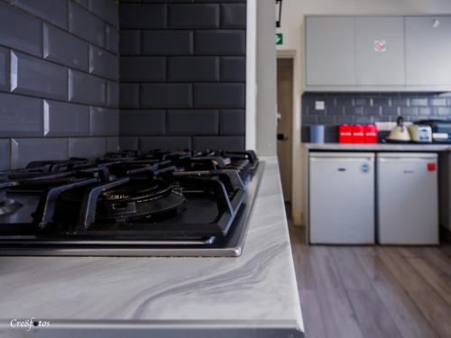 a kitchen with a stove top oven in a kitchen at WoodHus Lodge Fantastic Large Double Room 3 in Stoke on Trent