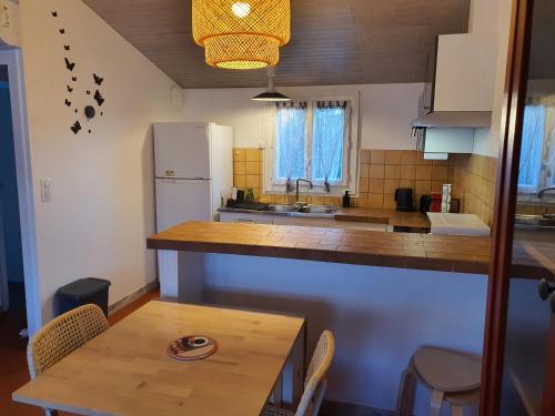 une petite cuisine avec une table et un réfrigérateur dans l'établissement Appartement cosy et climatisé pour 1 à 4 personnes 150m place Gambetta, à Casteljaloux