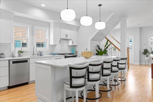 Luxurious OC Single Family Home with Hot Tub في أوشن سيتي: مطبخ أبيض مع جزيرة كبيرة مع كراسي بار