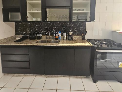 a kitchen with a sink and a stove at Lindo AP com vista para a Lagoa dos Ingleses in Nova Lima