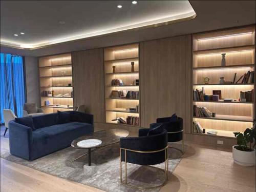 a living room with a couch and a table and shelves at Sky One Harmony in Box Hill