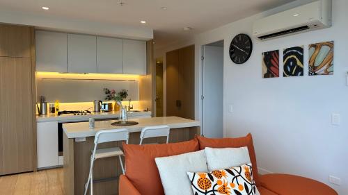 a kitchen and living room with a couch and a table at Sky One Harmony in Box Hill