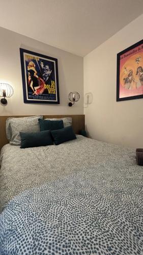 - une chambre avec un lit et deux affiches sur le mur dans l'établissement Cannes Beach appartements - Piscine proche mer, à Cannes