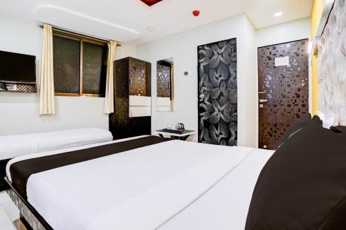 a bedroom with a white bed and a window at Super Collection O Asalpha near International Airport in Mumbai