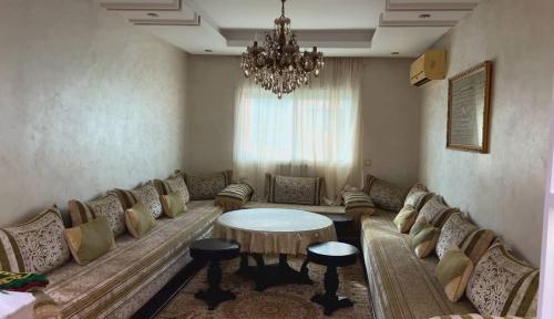a living room with a couch and a chandelier at appartement a louer in Beni Mellal
