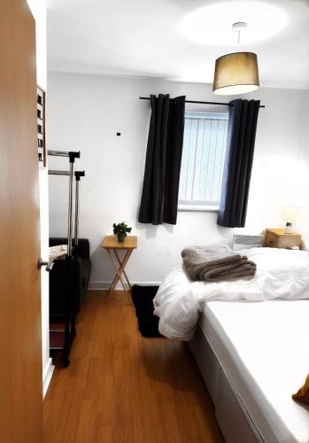 a bedroom with a bed and a window at 1 private room & a toilet in 2bed apartment in Manchester